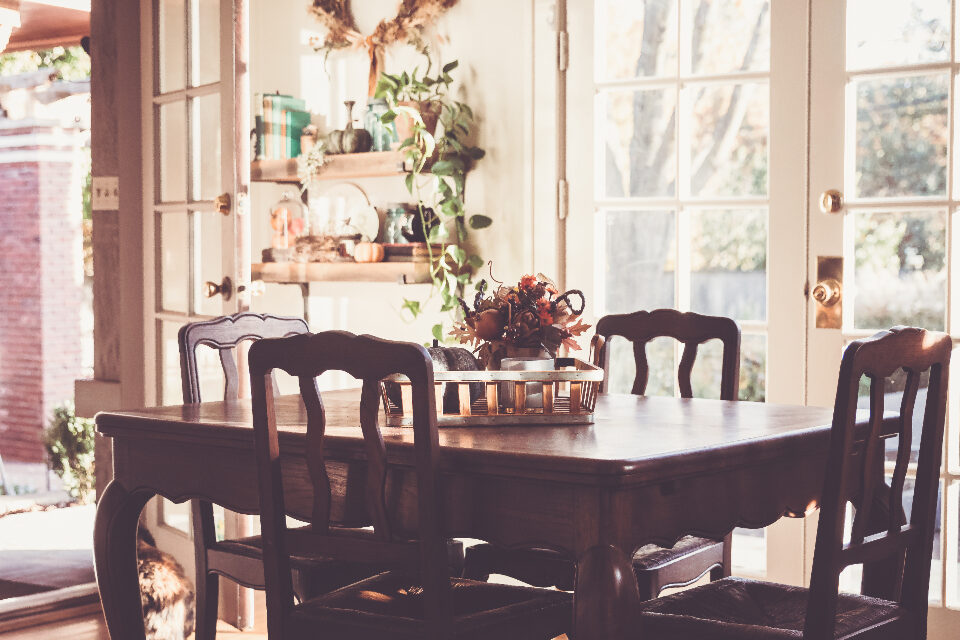A warm home interior by a bright window, a table set with plants and soft light.